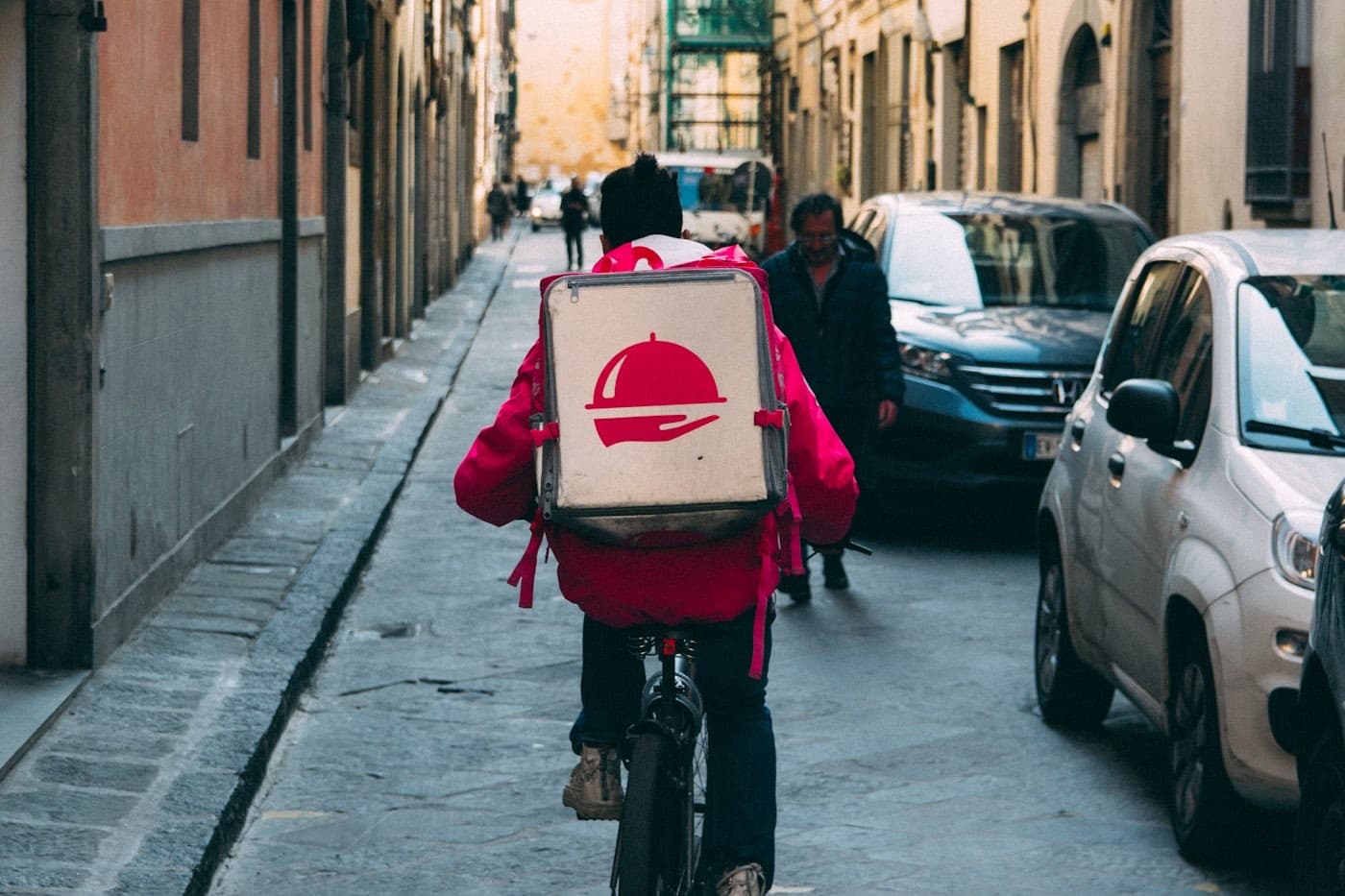 A courier riding out with an insulated delivery bag