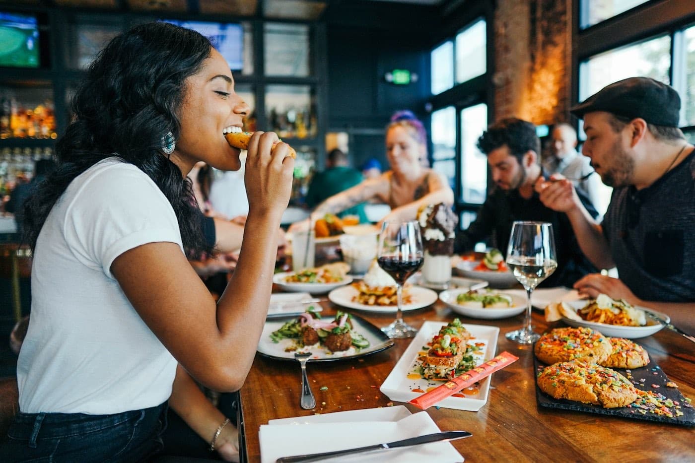 A full table of guests eating in a busy dining room